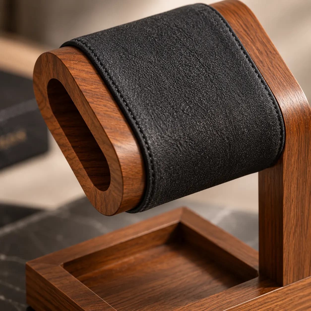 Detail van het bruine houten frame en de zwarte bekleding van de horlogestandaard